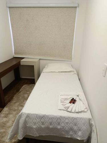 a small room with a bed with a towel on it at Residencial Luce Del Sole - Casa Nº 6 in Joinville