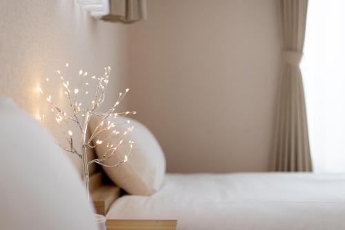 a vase filled with lights next to a bed at Gen-an no Sato - 幻庵の里 in Odawara