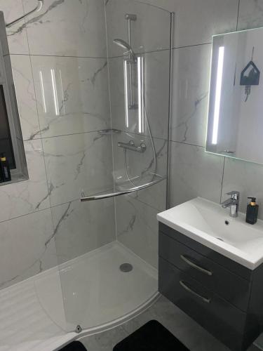 a white bathroom with a shower and a sink at Cosy Home In Nottingham Near QMC and University Free Parking! in Nottingham
