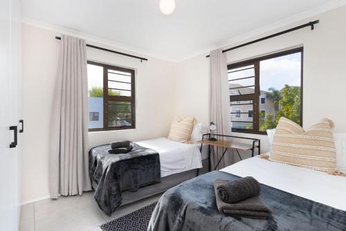 a bedroom with two beds and a window at Serengeti selfcatering apartments Perfect Stay in Bellville