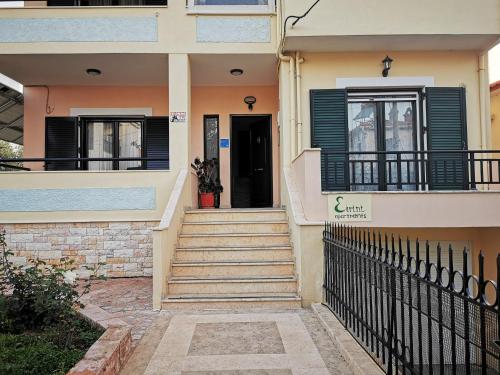 una casa con una escalera que conduce a la puerta principal en Studio Apartments Eirini, en Pyrgi Thermis