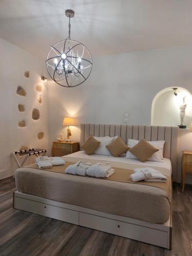 a bedroom with a large bed with a chandelier at George's point of view in Naousa