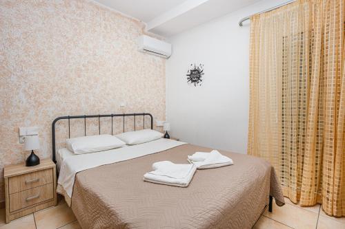 Sunrise Apartment في مدينة هيراكيلون: غرفة نوم عليها سرير وفوط