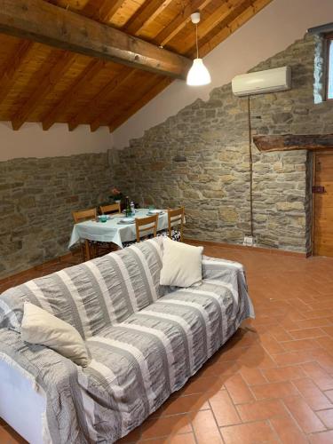 ein Sofa in einem Zimmer mit einer Steinmauer in der Unterkunft Casetta Ai Fiassoni in Parma