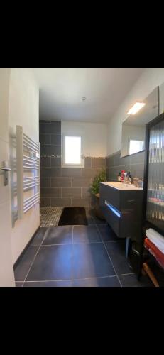 La grande salle de bains est pourvue d'un lavabo et d'une baignoire. dans l'établissement Maison individuelle avec extérieur et piscine, à Bagnols-sur-Cèze