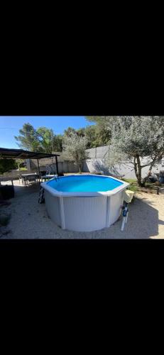 une grande baignoire installée dans une cour dans l'établissement Maison individuelle avec extérieur et piscine, à Bagnols-sur-Cèze