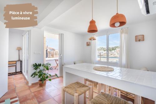 une cuisine avec un grand comptoir blanc et des chaises dans l'établissement Soooo Goudes * Vue mer * Luxe * Confort * Calme, à Marseille
