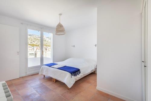 une chambre blanche avec un lit et une fenêtre dans l'établissement Soooo Goudes * Vue mer * Luxe * Confort * Calme, à Marseille
