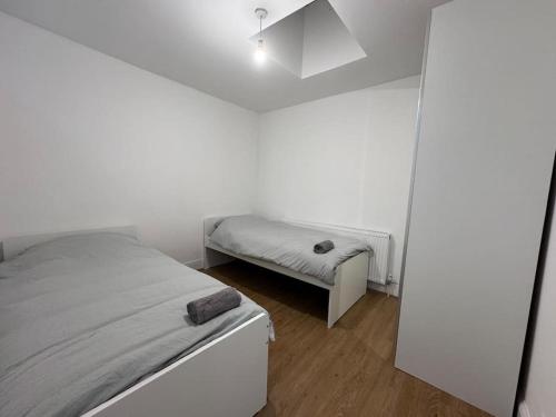 Elegant living, 3 bedroom modern house في لندن: غرفة نوم بيضاء بسرير ومقعد