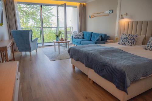 a bedroom with a bed and a living room at Szerokie Wody Sea & Sand Ustka in Ustka