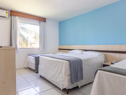 um quarto de hotel com duas camas e uma janela em JL Temporadas - Quarto Portobello Park Hotel em Porto Seguro