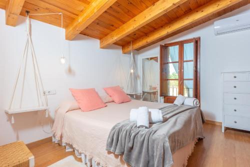a bedroom with a large white bed with pink pillows at Can Rosillo in Llucmajor