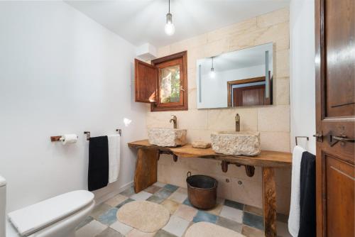 a bathroom with a toilet and a sink and a mirror at Can Rosillo in Llucmajor