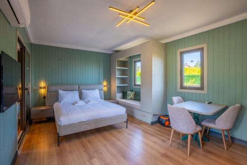 a bedroom with a bed and a table and chairs at Premium park rezidans in Kemer