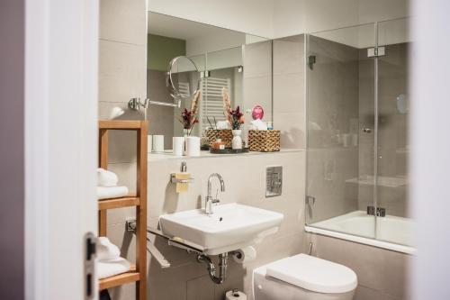 a bathroom with a sink and a toilet and a mirror at The Circus Apartments in Berlin