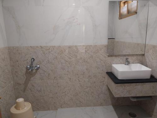 a bathroom with a sink and a toilet in it at Hotel Harshanaa Elite in Kanyakumari