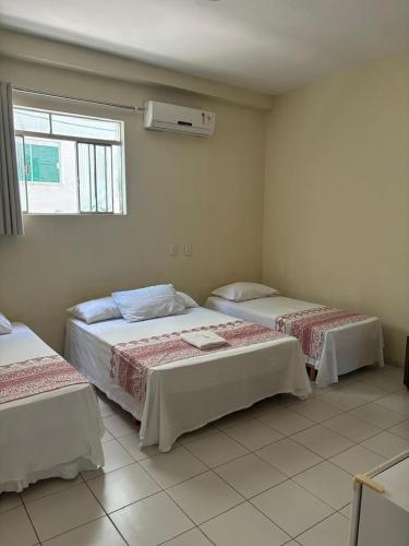 1 Schlafzimmer mit 2 Betten und einem Fenster in der Unterkunft San Felipe Hotel in Colinas do Tocantins