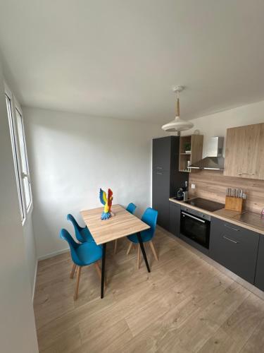 une cuisine avec une table en bois et des chaises bleues dans l'établissement Appartement des calanques, à Marseille