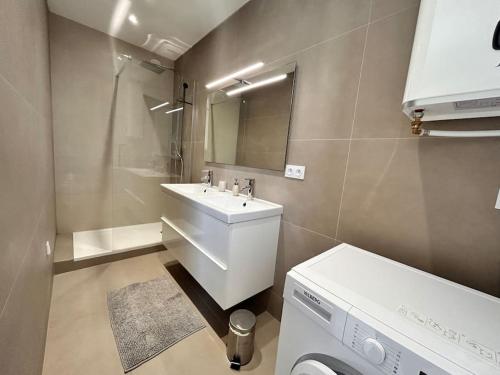 een badkamer met een wastafel en een wasmachine bij Rebeca - 4 pers Standing - Hyper centre -Terrasse in Saint-Raphaël