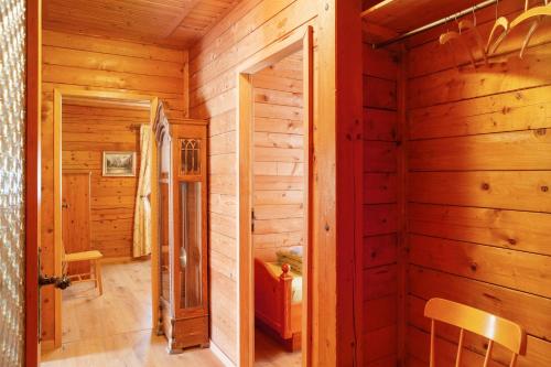a log cabin hallway with a door and a chair at Grashäusl in Grainau