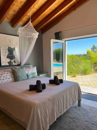 a bedroom with a large bed with a large window at Villa Alba in Aljezur