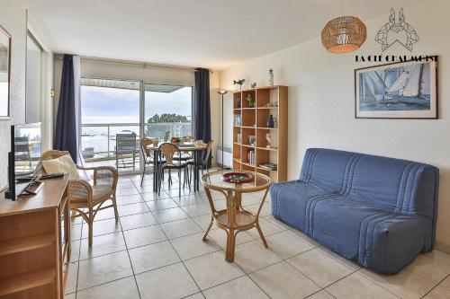 un salon avec un canapé bleu et une table dans l'établissement Ancora3 Appartement vue mer et place de parking, à Les Sables-dʼOlonne