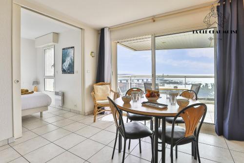 une salle à manger avec une table et des chaises et une fenêtre dans l'établissement Ancora3 Appartement vue mer et place de parking, à Les Sables-dʼOlonne
