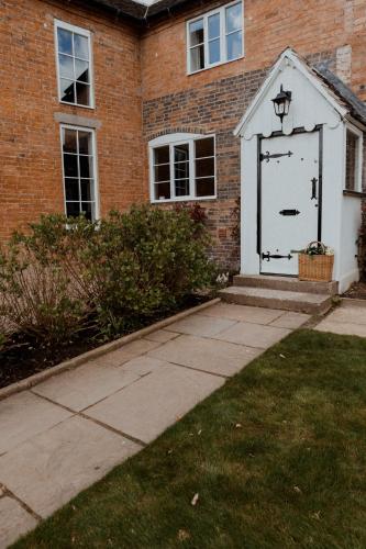 a white door on the side of a brick building at The Fitzherbert Farmhouse in Swynnerton