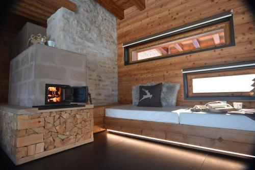 Cabaña de madera con chimenea y cama en Maso Stella en Castello Tesino