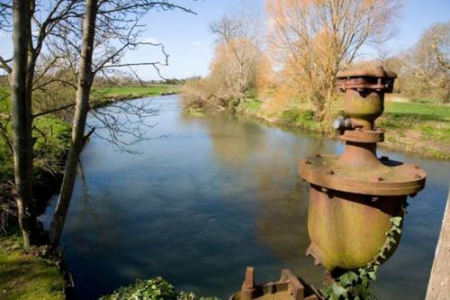 a fire hydrant sitting next to a river at Rare & exclusive country cottage in Hurn