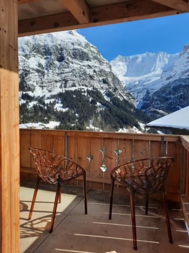 two chairs on a porch with a view of a mountain at Boutique Hotel Panorama Grindelwald in Grindelwald