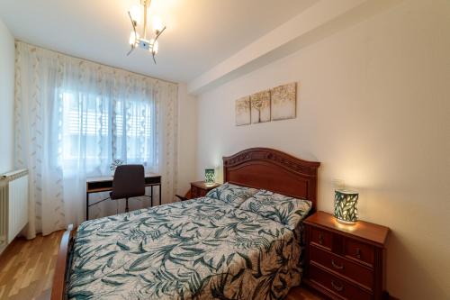 1 dormitorio con cama, escritorio y ventana en Ca Mari Apartamento con garaje en Zamora