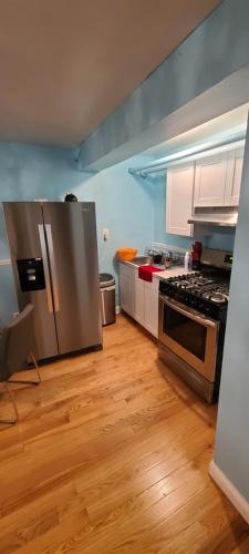 a kitchen with stainless steel appliances and wooden floors at Private 1 Bedroom in Boston in Boston