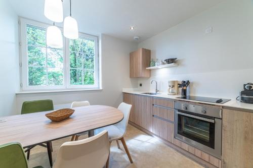 une cuisine et une salle à manger avec une table et des chaises dans l'établissement Le Jungle - Appt pour 6 avec parking privé, à Paray-le-Monial