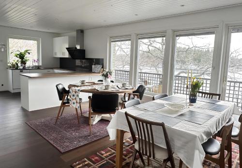 uma cozinha e sala de jantar com mesa e cadeiras em The Luxurious Lakeview Villa near Stockholm em Estocolmo