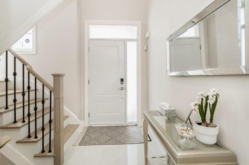 um corredor com uma porta branca e uma mesa de vidro com flores em Pristine Pet & Smoke Free 4-Bedroom home near Canada's Wonderland em Vaughan