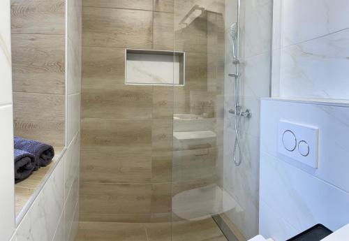 a shower with a glass door in a bathroom at Homestead - Domačija - Nabergoj in Podnanos