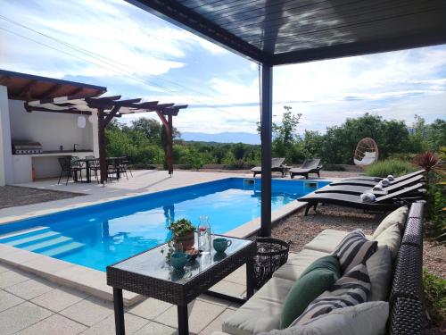 ein Schwimmbad mit Couch und Tisch daneben in der Unterkunft Lazy 8 Villa in Garica