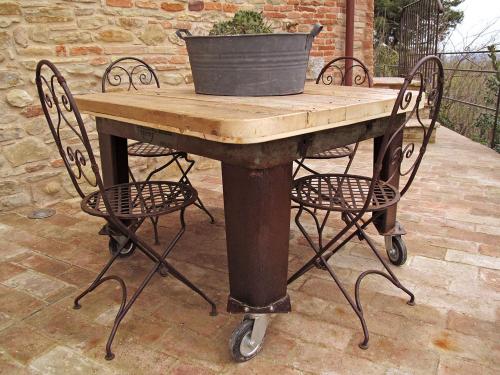 a table with two chairs and a potted plant on it at Castello di Granarola Relais - Adults Friendly - in Gradara