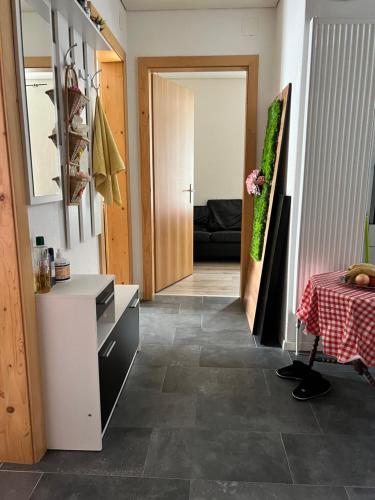 a hallway with a room with a table and a door at Pension des Draizes in Neuchâtel