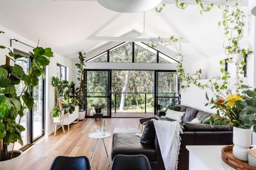 a living room with a couch and lots of plants at The Green Door-Karri retreat in Margaret River Town