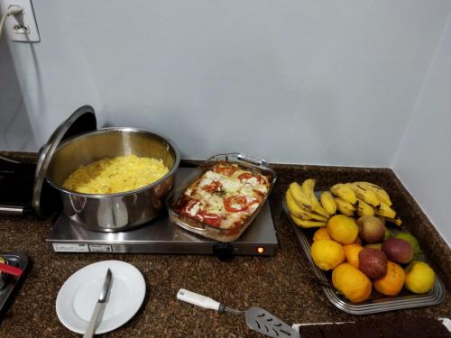 a counter top with a buffet of food and fruit at Hotel Mattes in Joinville