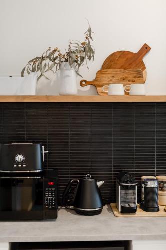 a kitchen counter with a microwave and a wooden bird on a shelf at The Green Door-Karri retreat in Margaret River Town