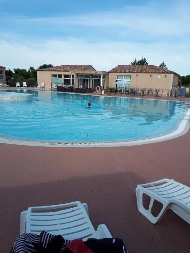 une grande piscine avec deux chaises longues devant dans l'établissement Maison conviviale à Aubignan avec piscine partagée, à Aubignan