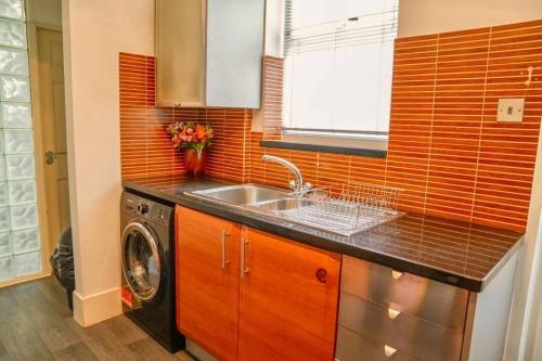 a kitchen with a sink and a washing machine at Pass the Keys Stylish 5 bed near major companies in Nottingham