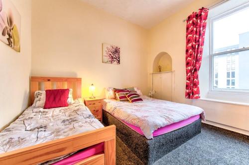 sypialnia z 2 łóżkami obok okna w obiekcie Edinburgh Morrison Central ApartHotel w Edynburgu