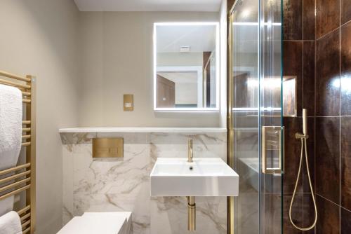 y baño con lavabo y ducha. en Dragon Suites - City Centre 2 Bed Luxury Mews House, en Edimburgo