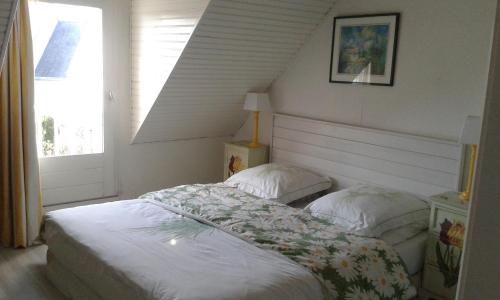 une chambre avec un lit et une fenêtre dans l'établissement Babounia, à Batz-sur-Mer