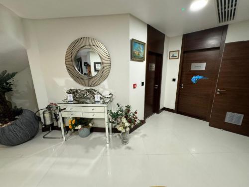 a bathroom with a mirror and a table with flowers at Rafayel Hotel & Spa in London