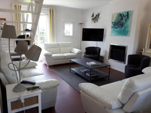 - un salon avec des canapés blancs et une télévision dans l'établissement Babounia, à Batz-sur-Mer